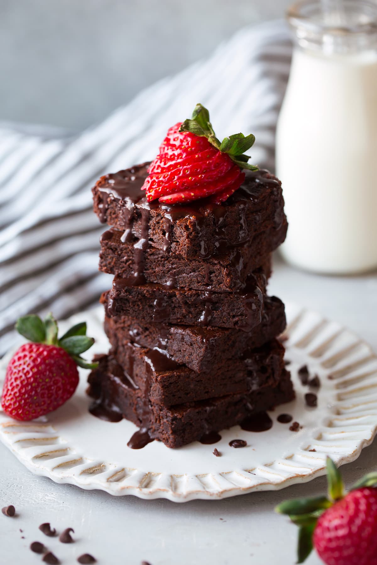 stack of healthy brownies topped with fudge sauce and strawberries
