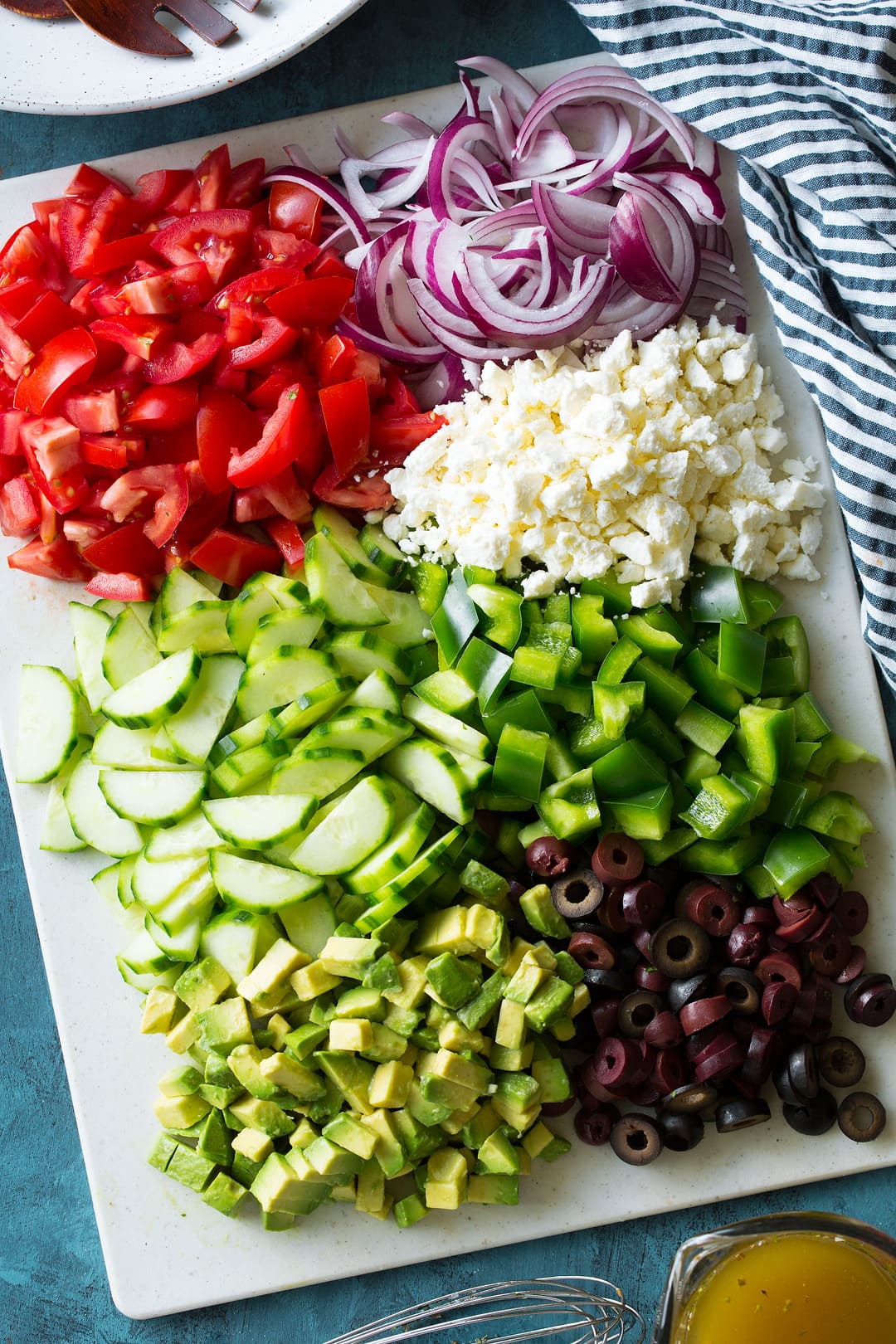 Ingredients for making a Greek Salad chopped up on a cutting board
