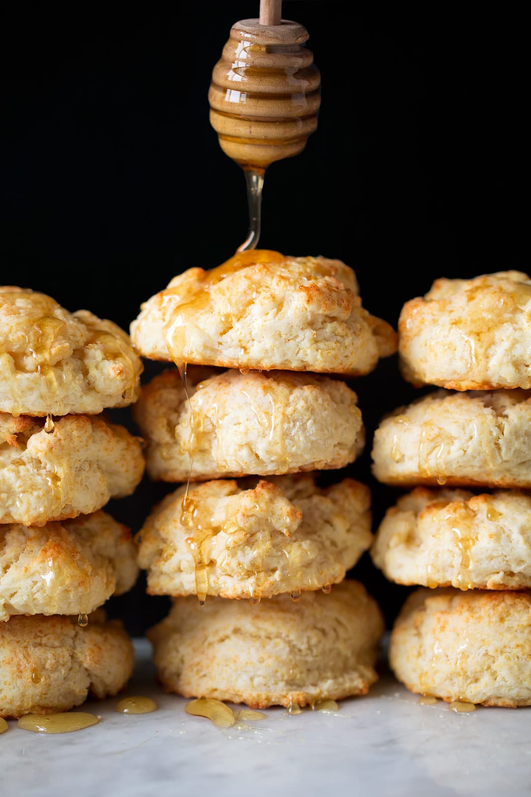 drizzling honey onto stacks of Buttermilk Drop Biscuits