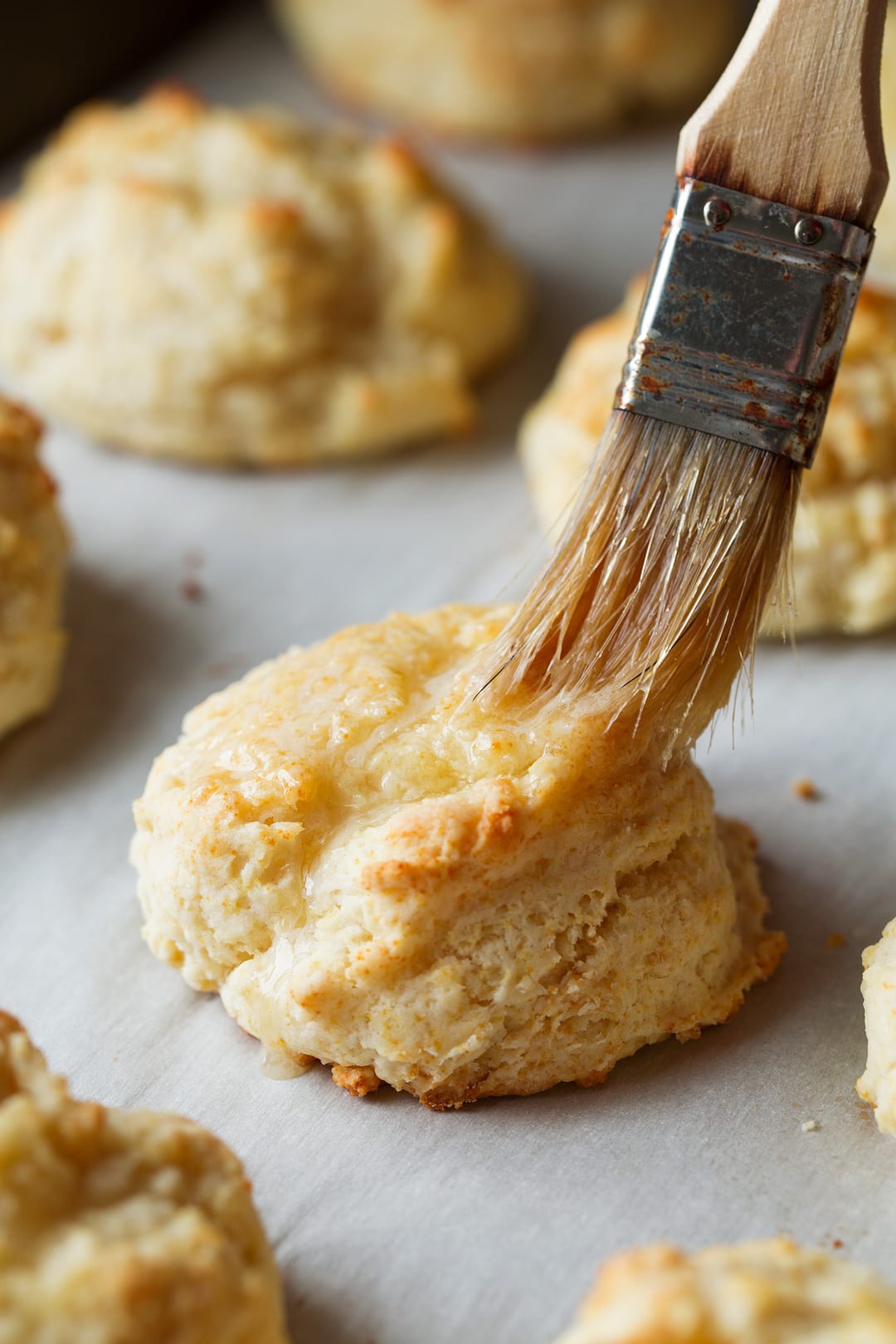 brushing butter onto the tops of Buttermilk Drop Biscuits
