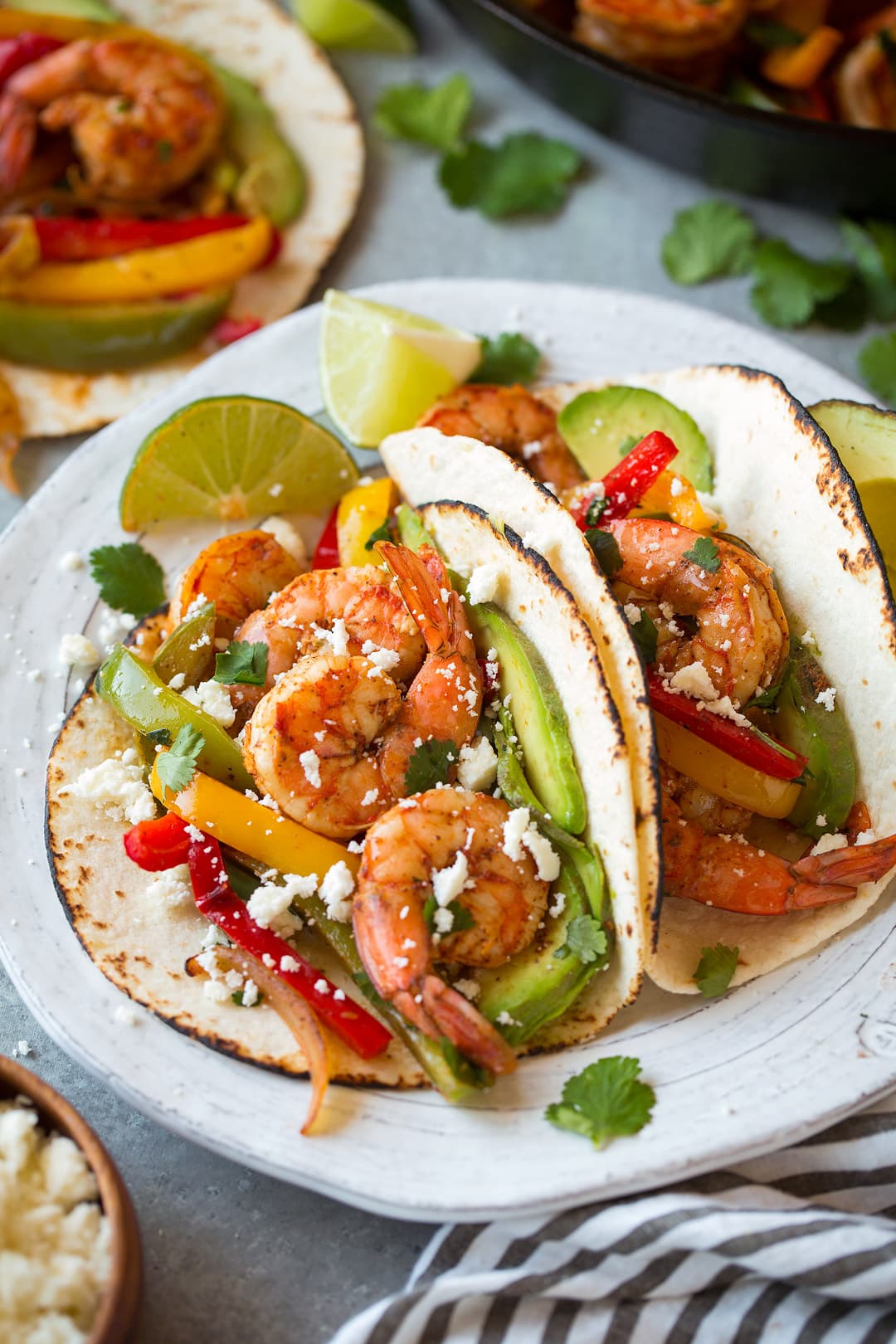 two Shrimp Fajitas with lime wedges on a plate