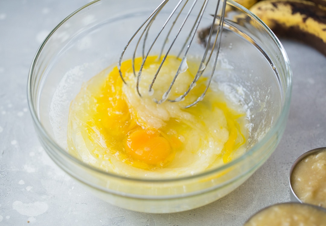 eggs in banana bread mixture in a glass bowl