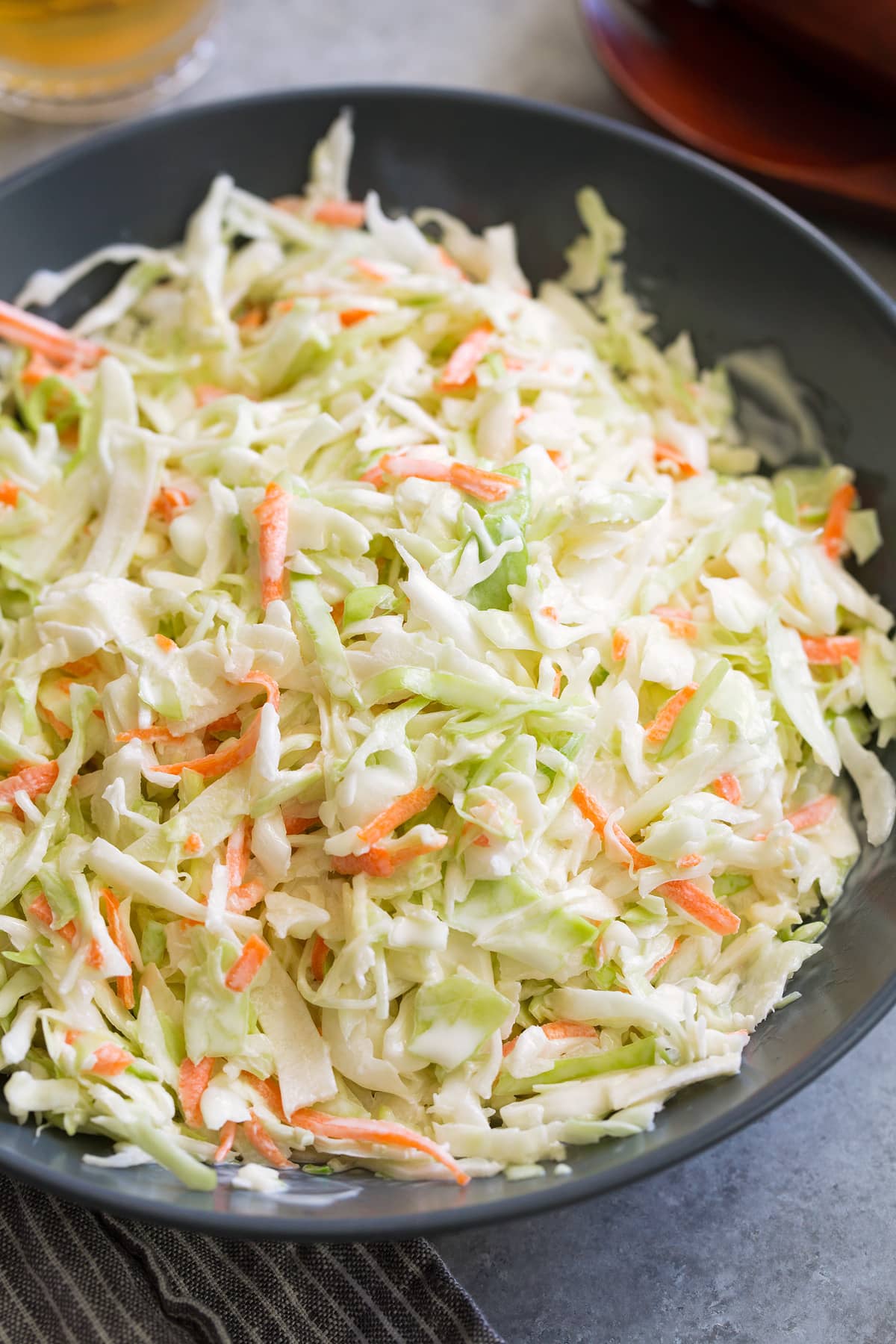 Coleslaw in a blue serving bowl set over a grey surface.