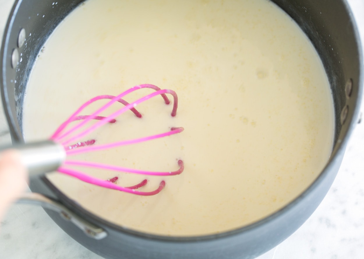 adding milk to mixture in saucepan