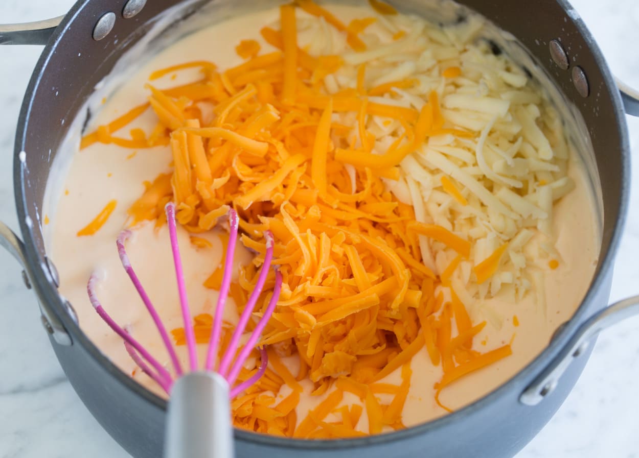 whisking together a mac and cheese sauce