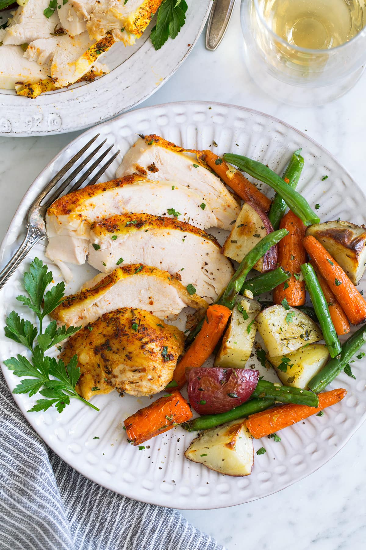 Slow Cooker Chicken serving on plate with roasted veggies