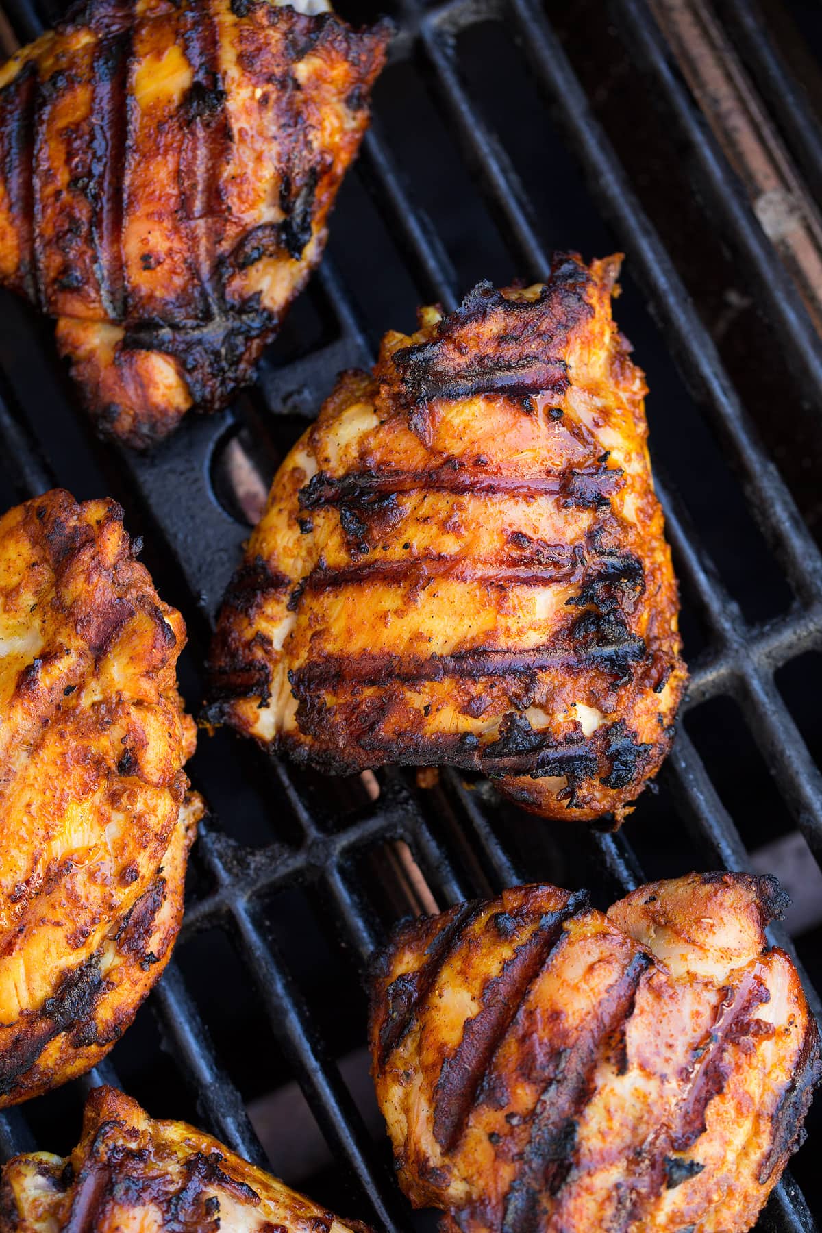 5 pieces of Tandoori Chicken shown on a grill.