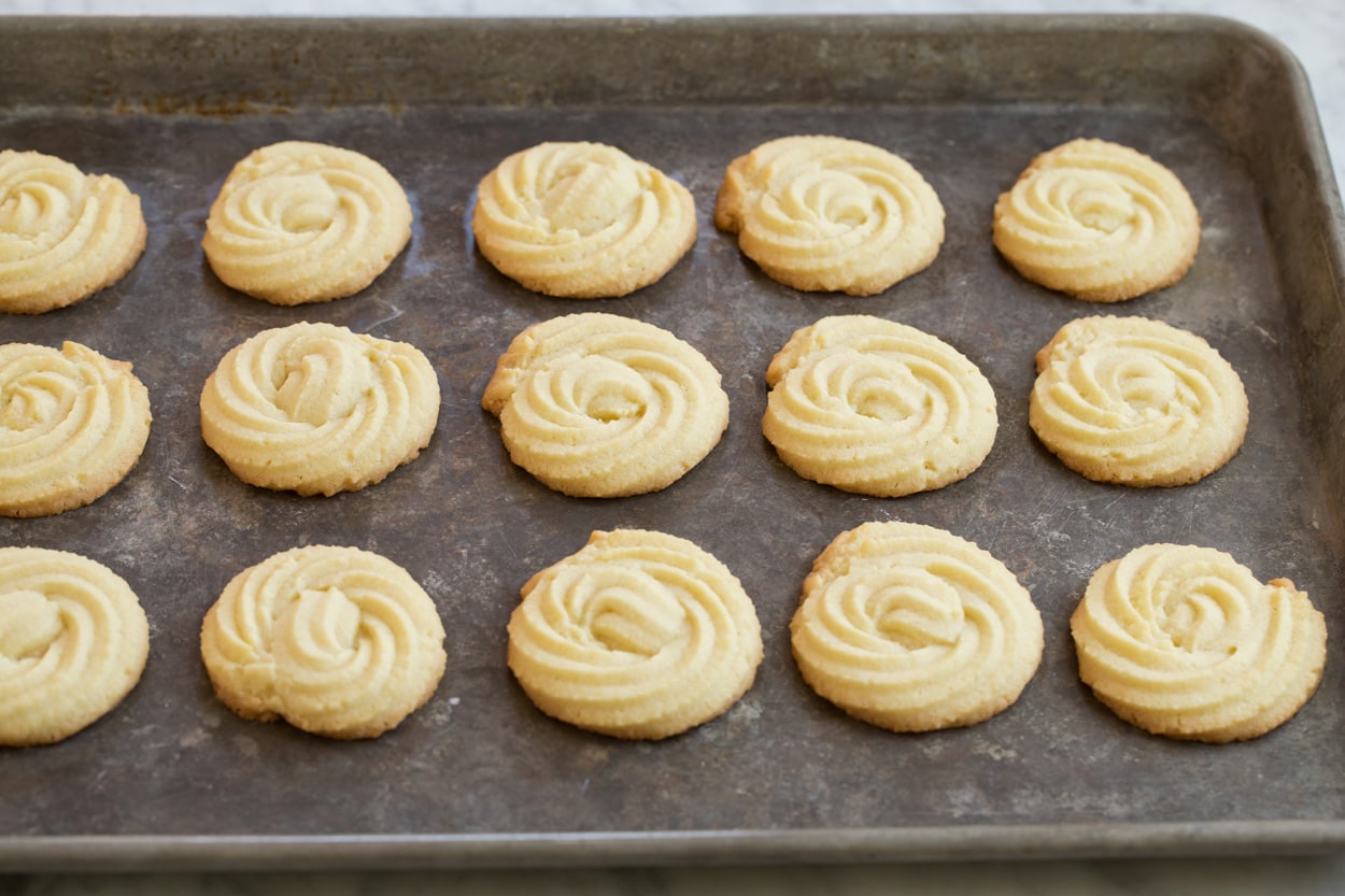 Butter cookies on a baking sheet after baking.