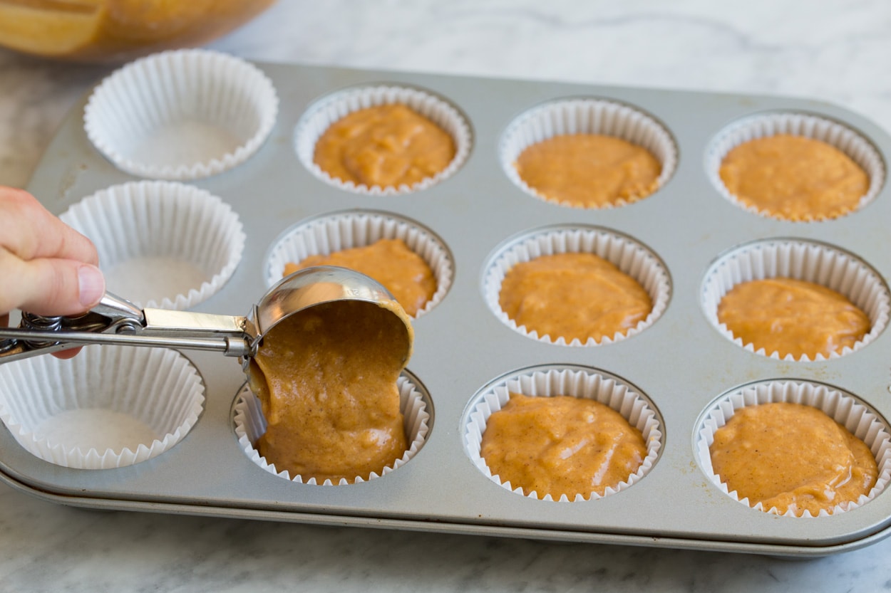 Pumpkin Muffins shown here adding batter to muffin pan