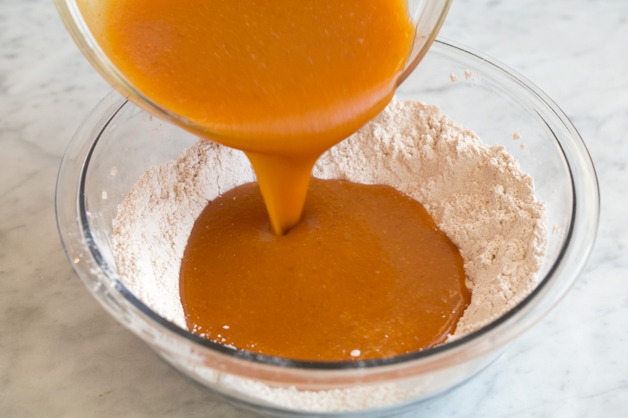Pumpkin muffins shown here mixing wet ingredients and dry ingredient for batter in mixing bowl