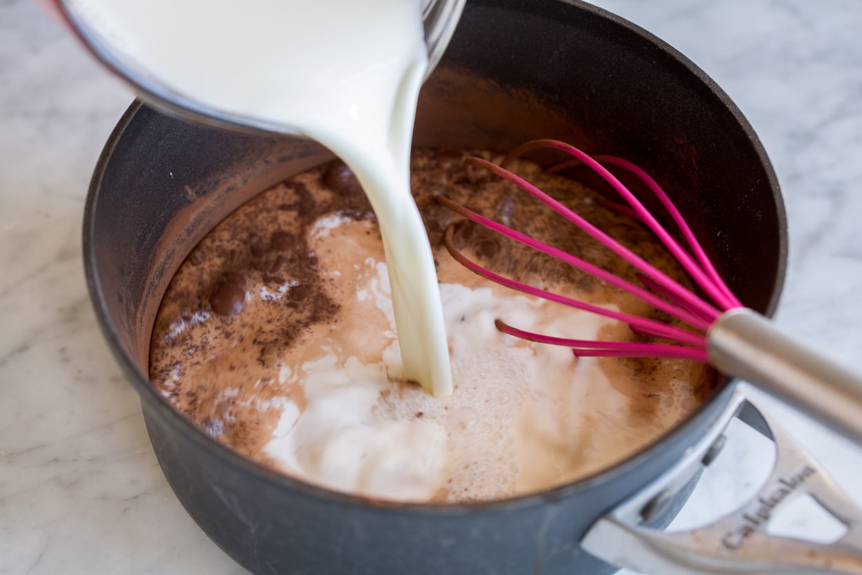 Shown here milk is being added to cocoa, sugar and cornstarch in a medium saucepan to make hot chocolate.