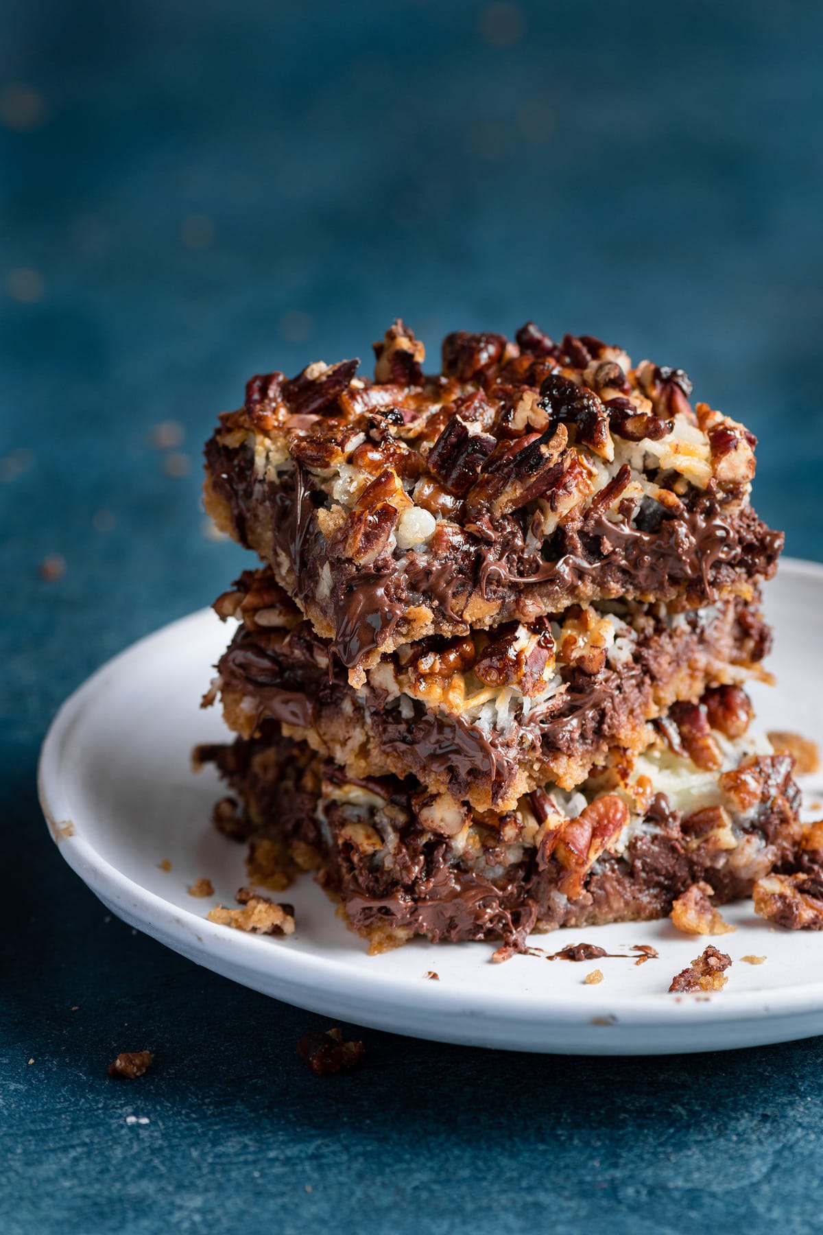 Stack of seven layer magic bars on a dessert plate.