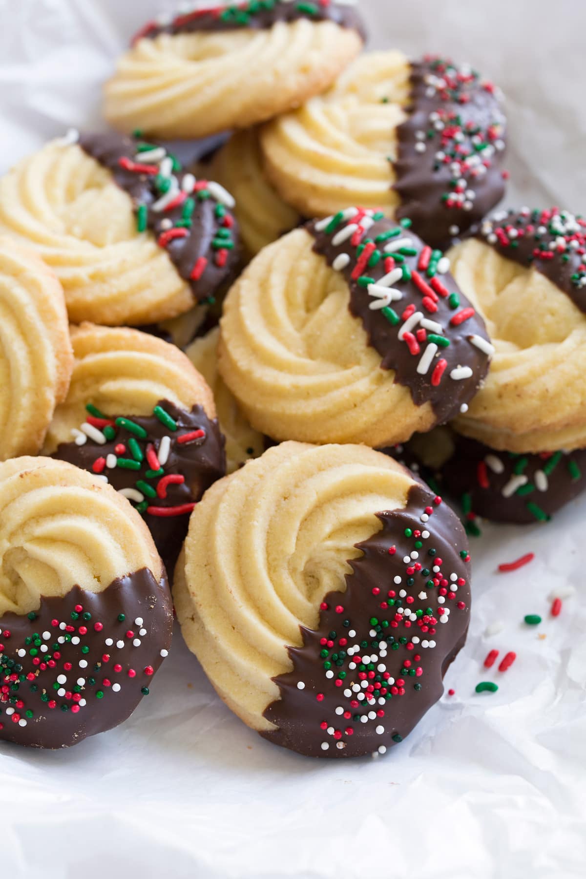 Butter cookies dipped in chocolate and covered with Christmas sprinkles.