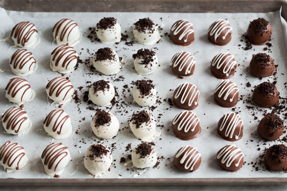 Rows of finished Oreo balls on a parchment paper lined baking sheet.