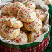 Ricotta cookies stacked in a Christmas tin.