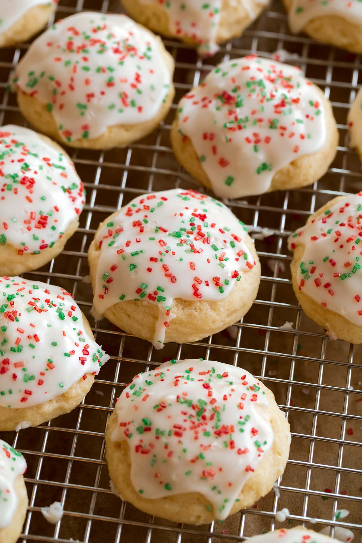 Close up photo of ricotta cookies on a cooling rack after covering with icing.