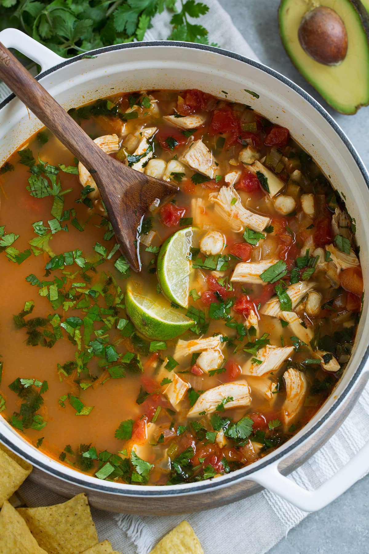 Overhead image of chicken posole in a white pot.