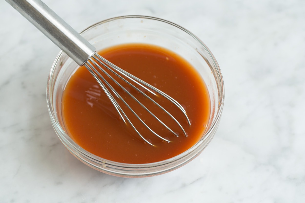 Whisking sweet and sour sauce in mixing bowl