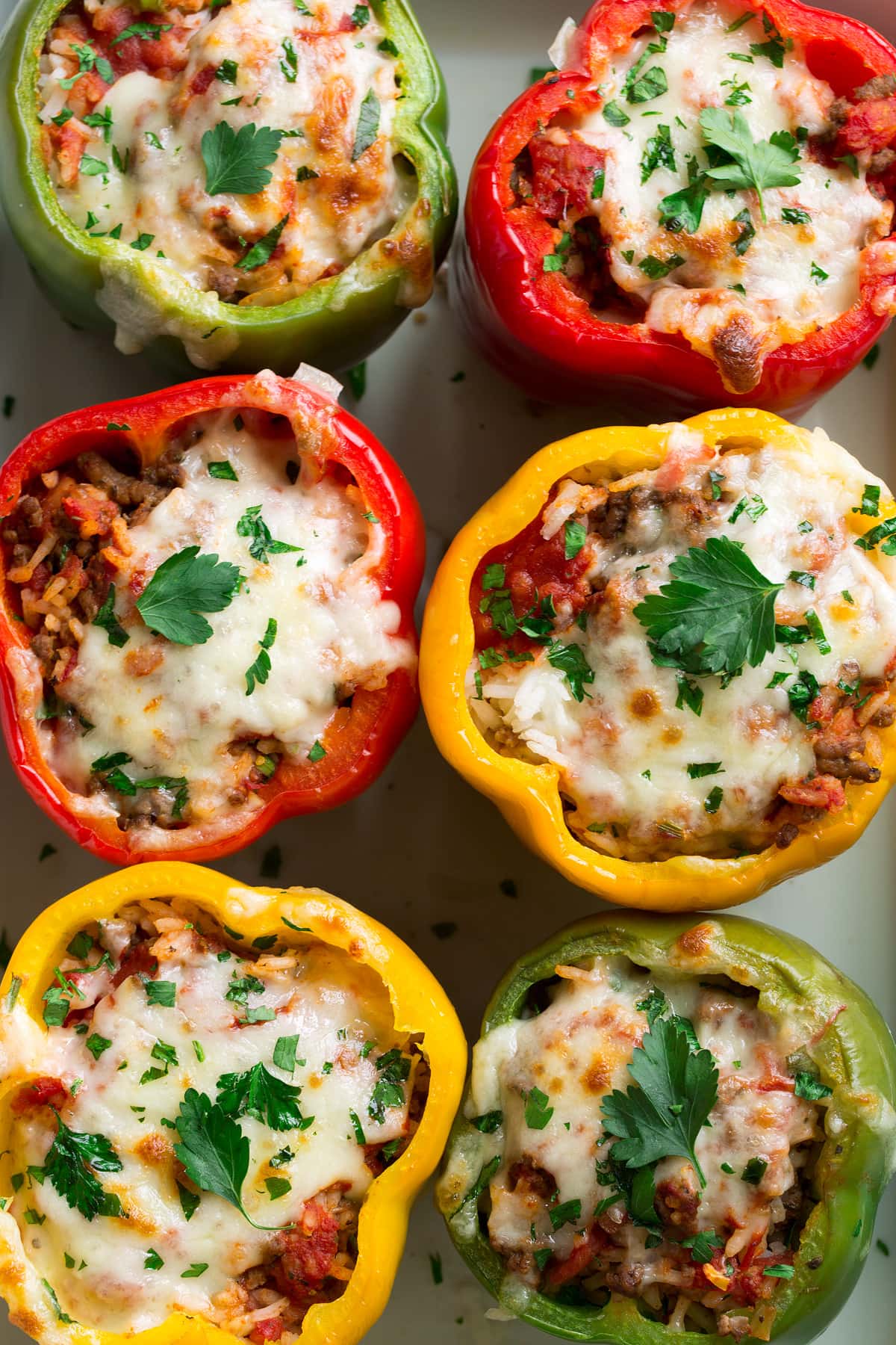Close up overhead image of stuffed peppers in a baking dish. 