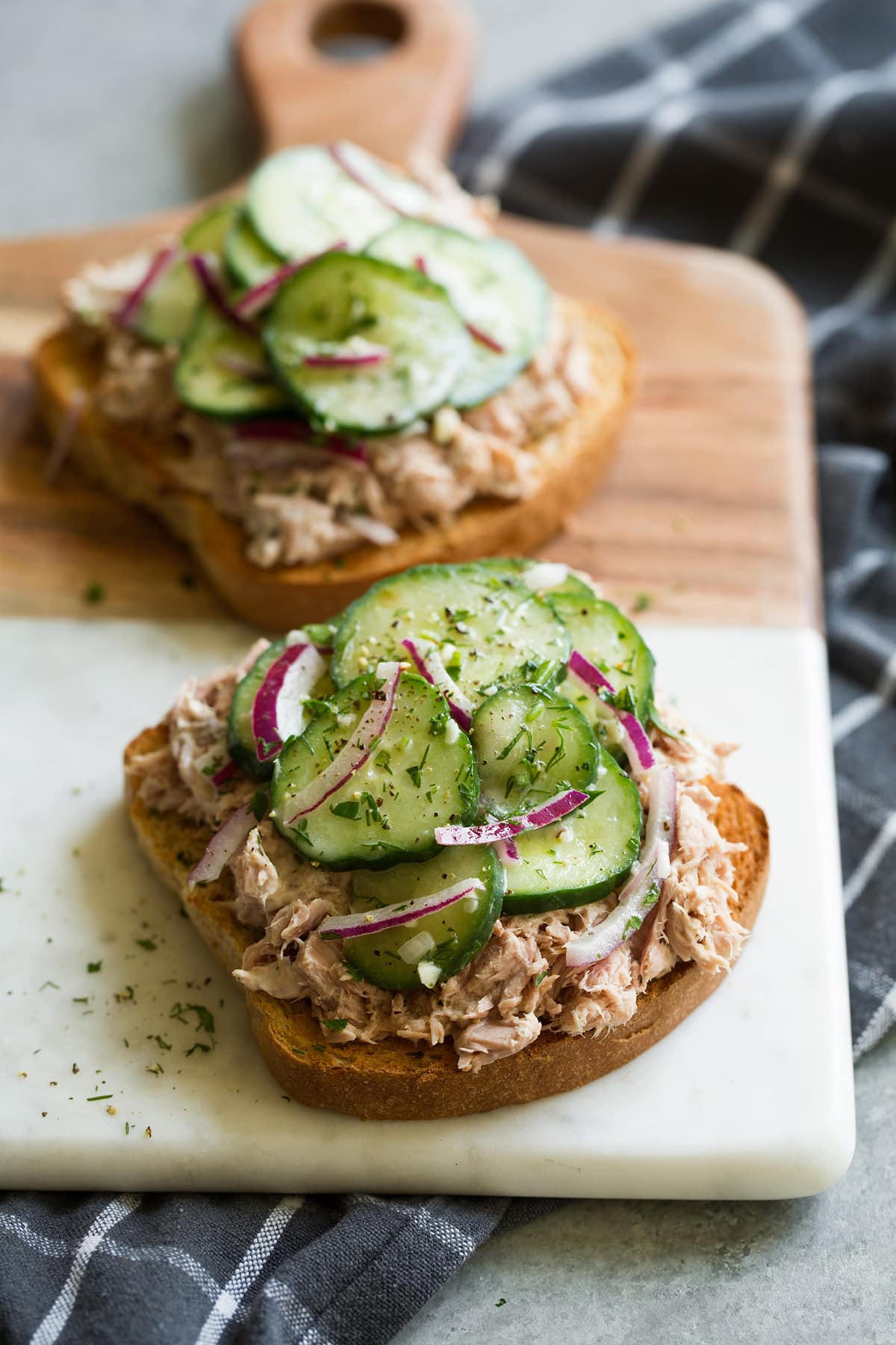 Cucumber salad served on top of an open faced tuna salad sandwich. Served with a side of potato chips. This is a serving suggestion.