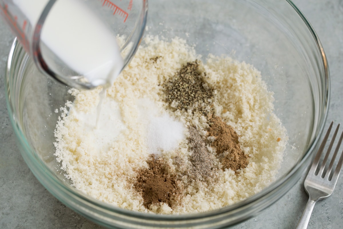 Showing how to make Swedish dumplings. Mix fresh breadcrumbs with spices and milk.