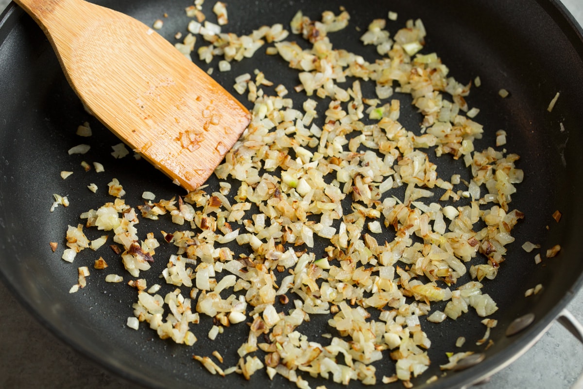 Sauté onion and garlic in butter in a large skillet.