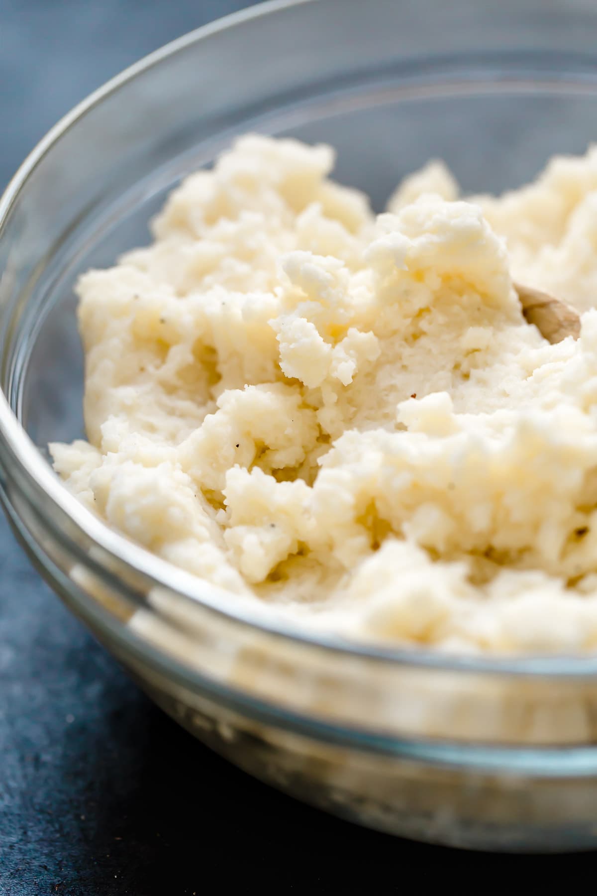 Fluffy mashed potatoes in a glass mixing bowl.