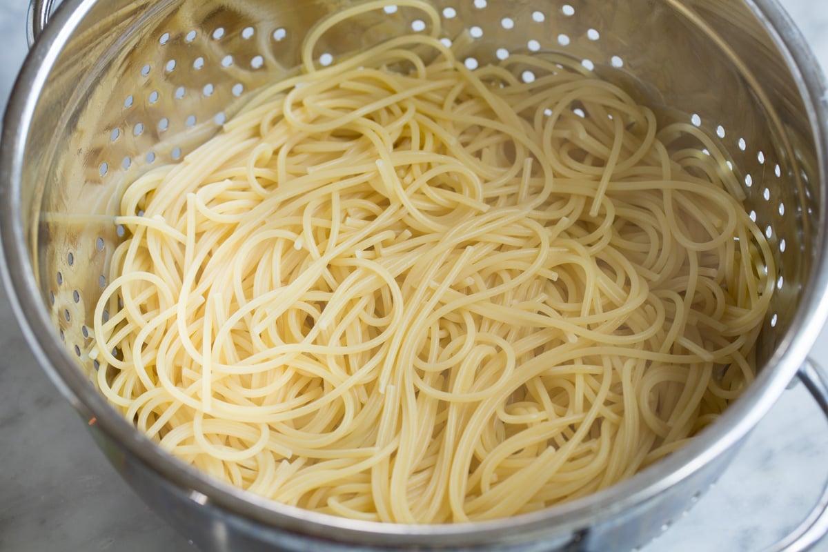 Cooked spaghetti pasta in a colander.