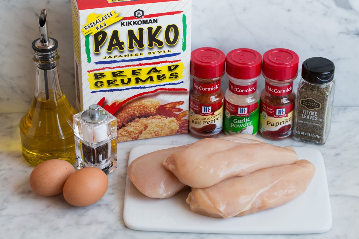 Ingredients needed to make chicken nuggets shown here including chicken breasts, panko, thyme, paprika, garlic powder, cayenne pepper, eggs, olive oil.