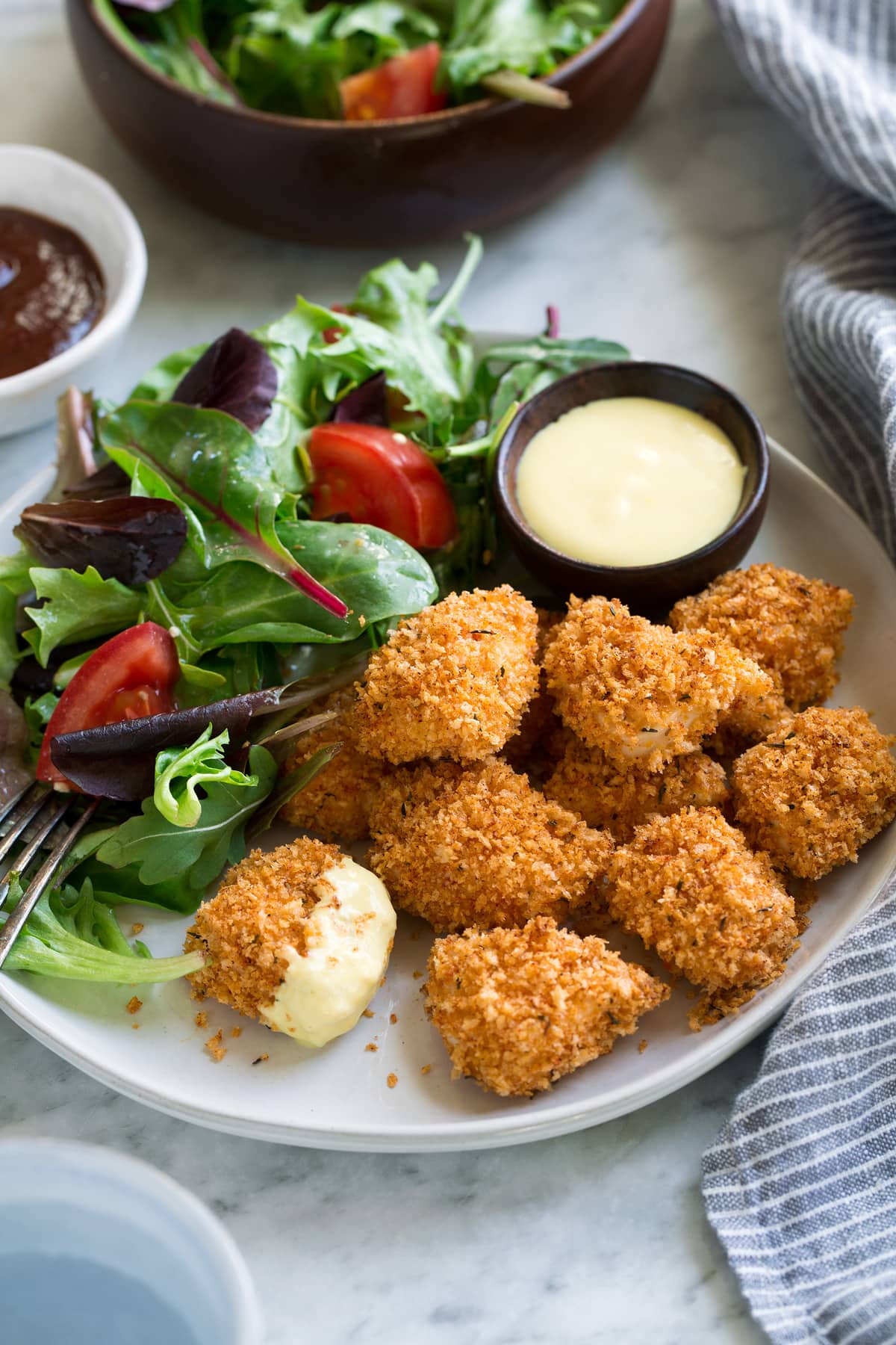 Chicken Nuggets on a serving plate with a side salad.