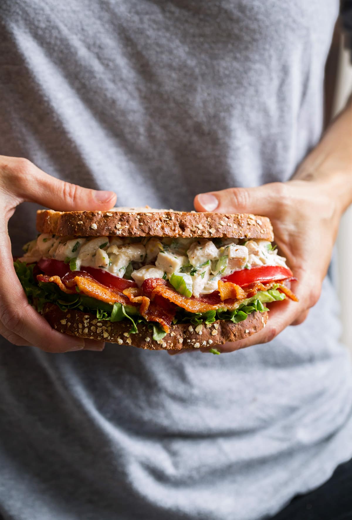 Person holding chicken salad sandwich
