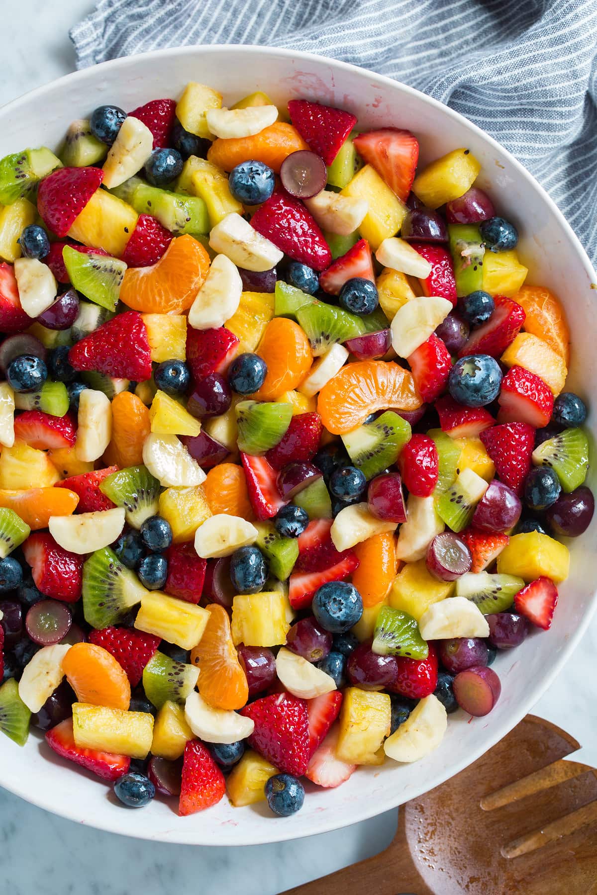 Fruit Salad with rainbow of colors in a large white serving bowl.