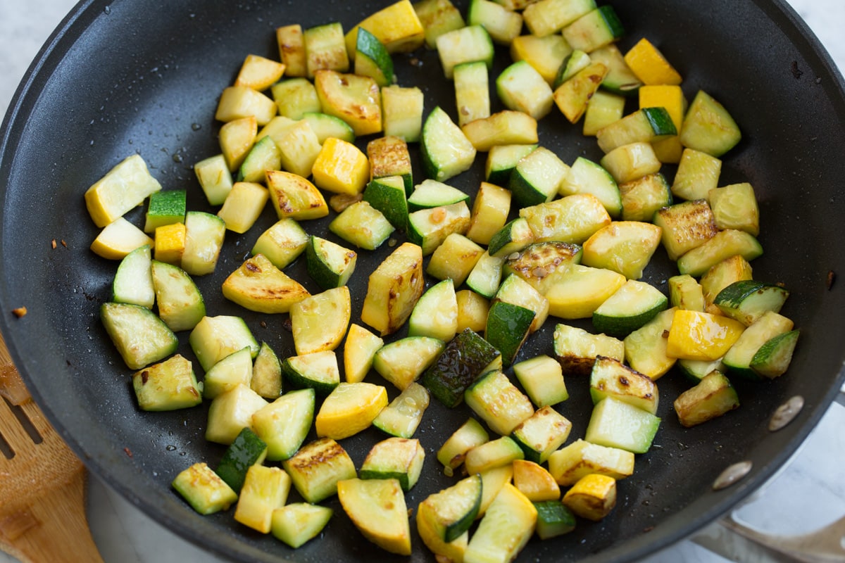 Sauteed zucchini and yellow squash in a large skillet.