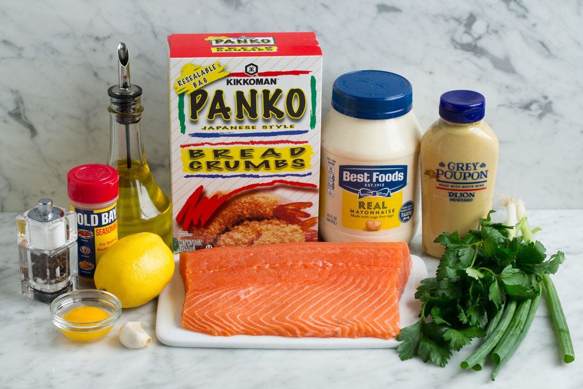 Ingredients needed to make salmon patties including mayonnaise, dijon mustard, panko, olive oil, green onions, parsley, salmon, lemon, egg yolk, garlic, old bay seasoning, salt and pepper.