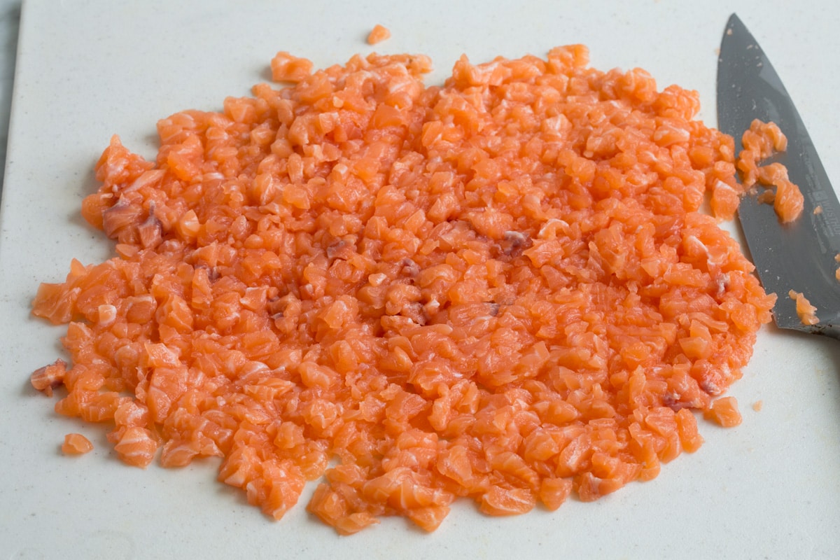 Finely diced salmon on a cutting board.
