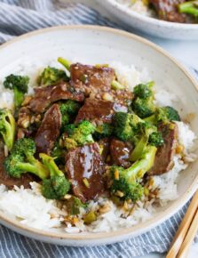 Beef and broccoli over white rice in a bowl.