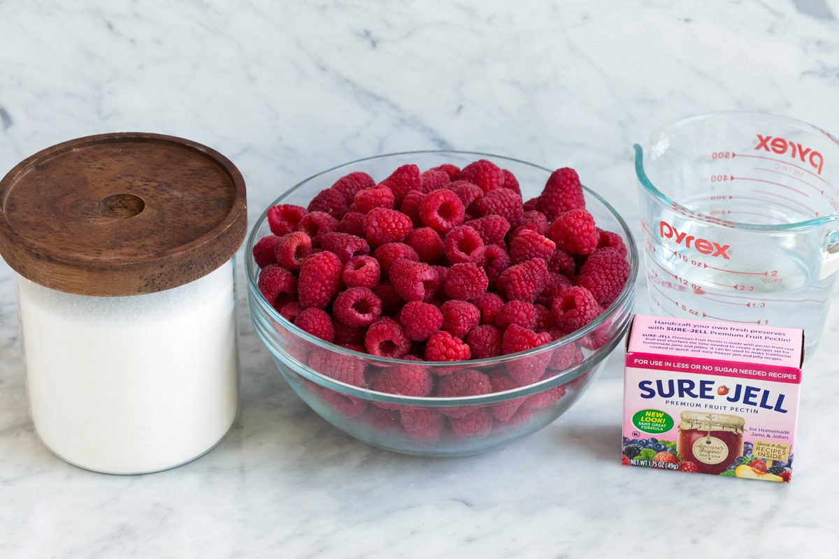 Ingredients needed to make raspberry jam.