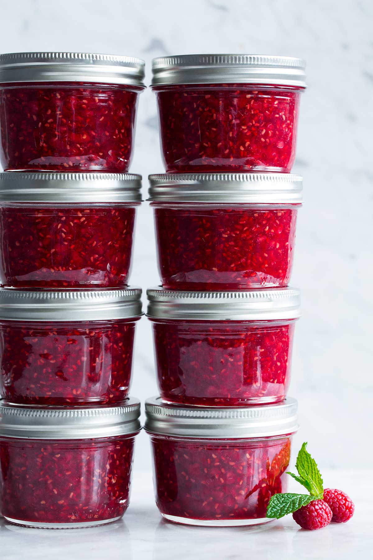 Raspberry jam in small glass mason jars.
