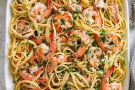 Shrimp scampi on a platter tossed with linguine pasta.
