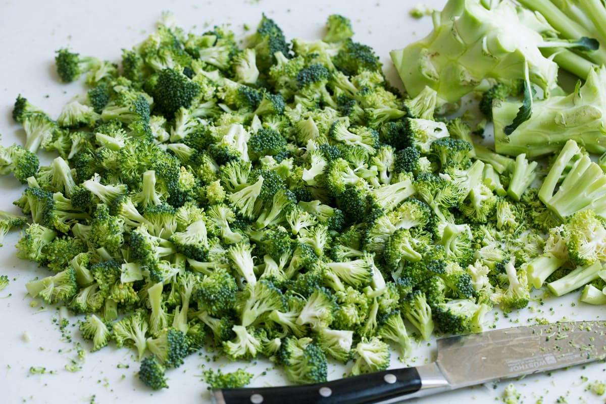Chopping broccoli florets into tiny bits.
