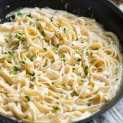 Alfredo sauce and fettuccine in a skillet