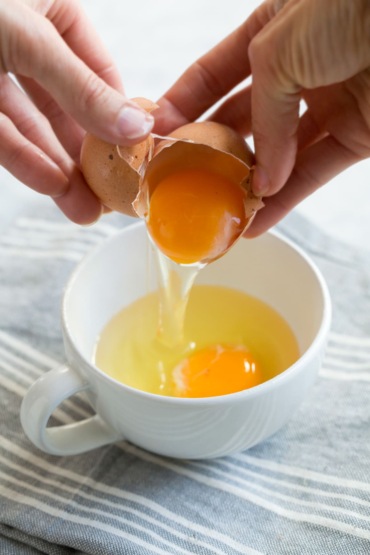 cracking egg into a mug