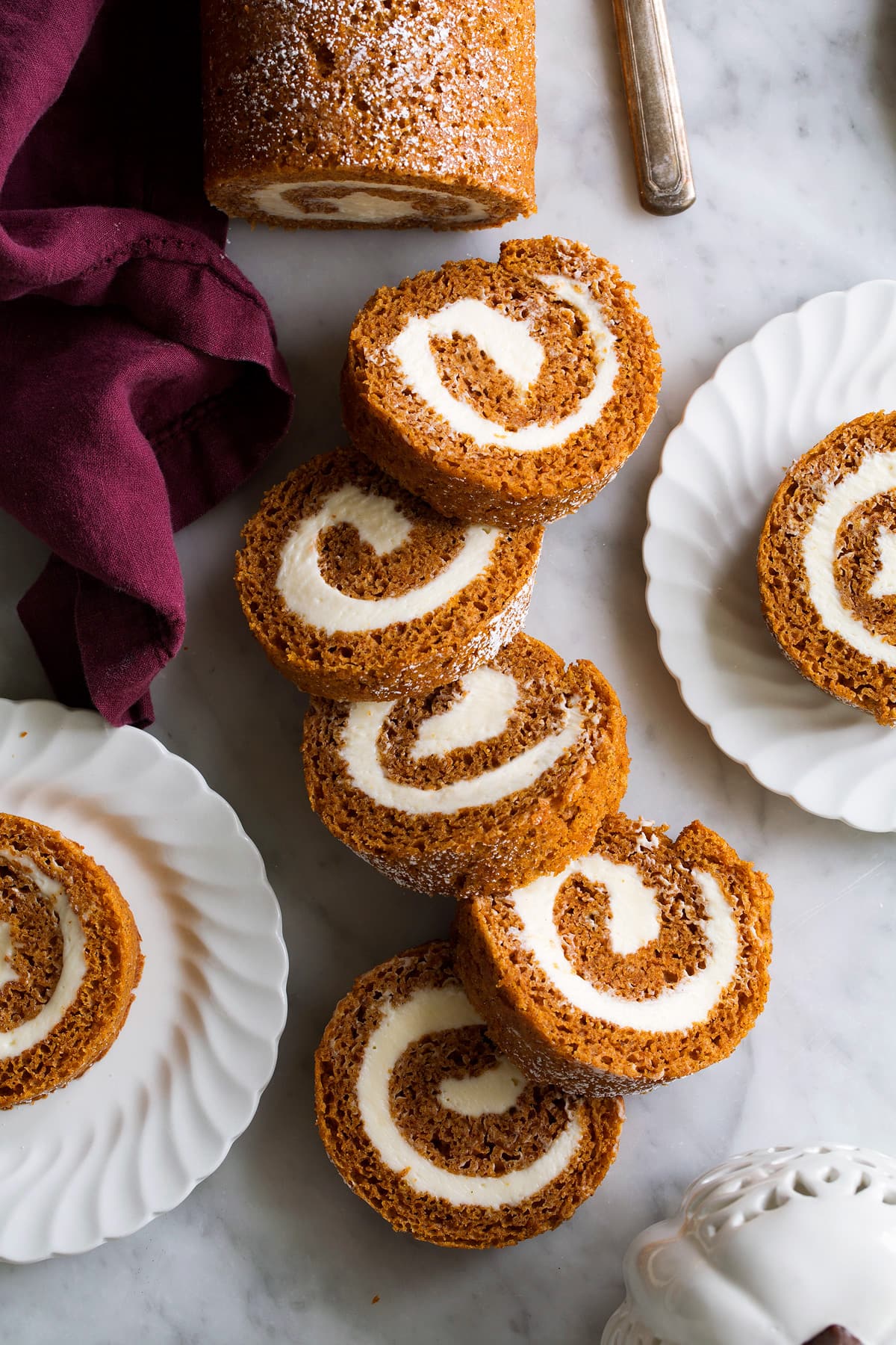 Sliced pumpkin roll on a marble surface.