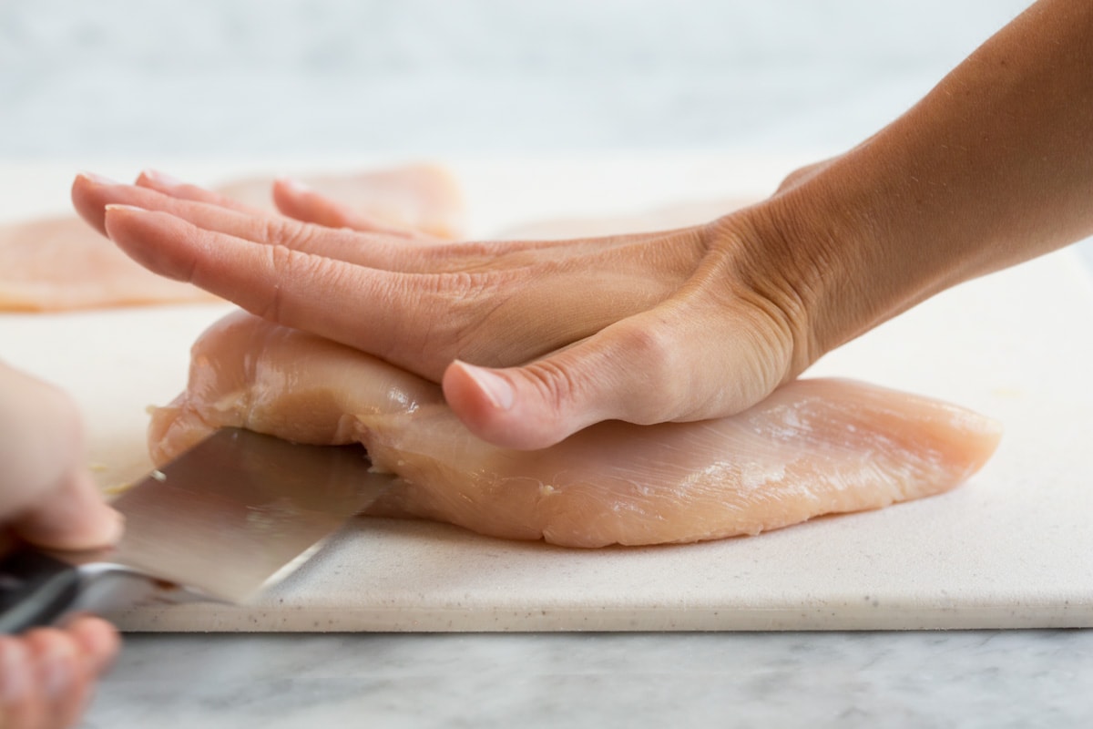 Showing how to slice a chicken breast in half to create two cutlets.