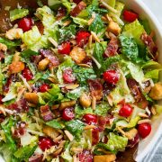 The Best Salad in a large salad bowl. Salad includes romaine lettuce, bacon, croutons, parmesan, swiss cheese, almonds, grape tomatoes and lemon vinaigrette dressing.