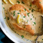 Close up image of chicken breasts in pan in a creamy lemon romano sauce.