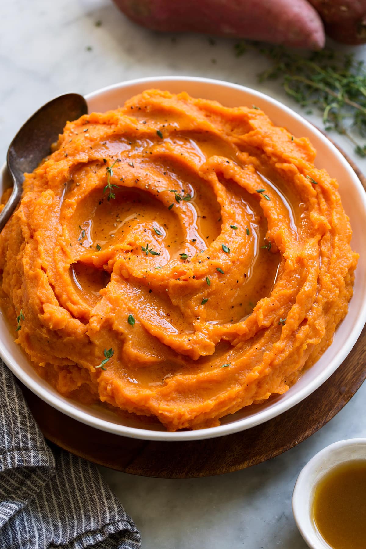 Image of bowl full of mashed sweet potatoes with melted butter on top.