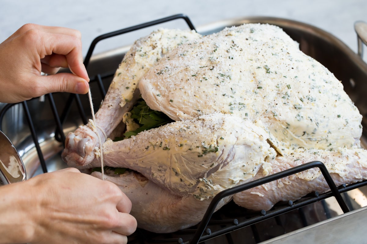 Trussing turkey with kitchen twine.