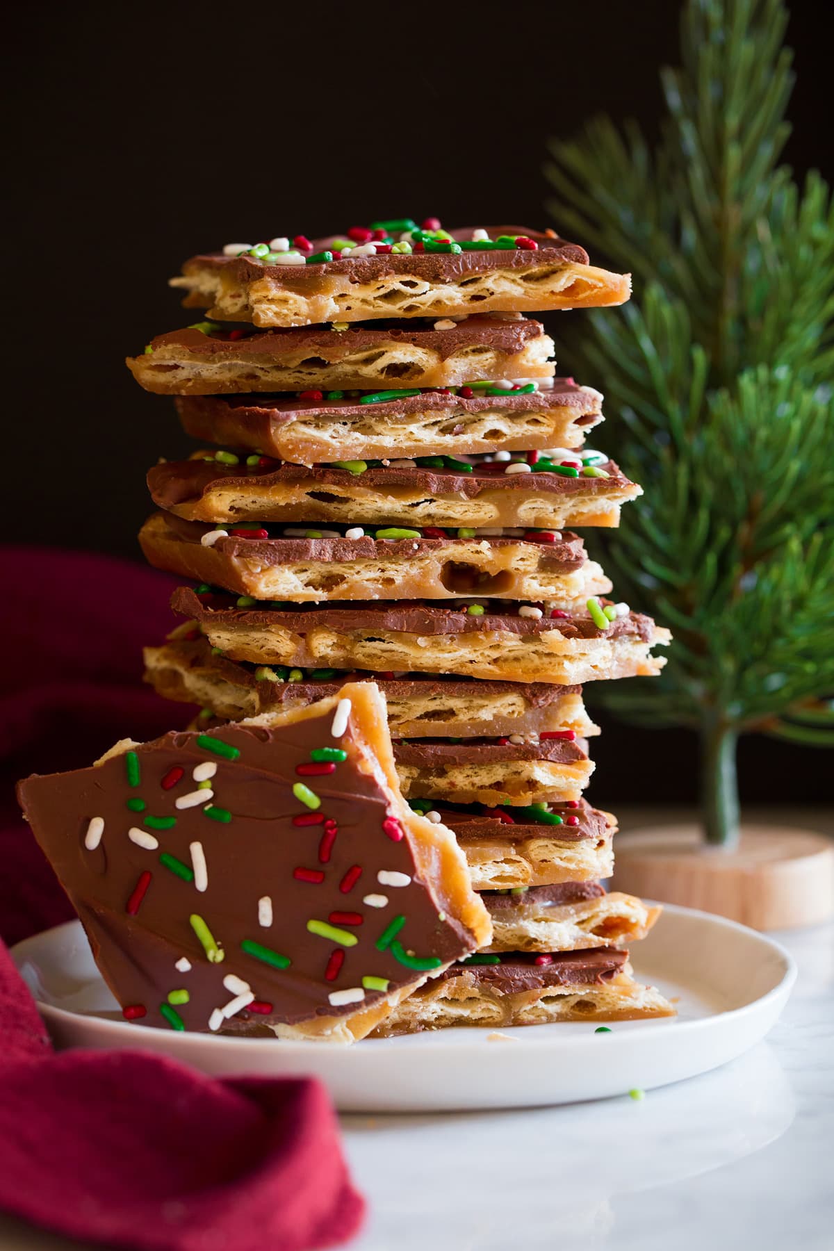 Tall stack of homemade Christmas Crack on a white dessert plate.