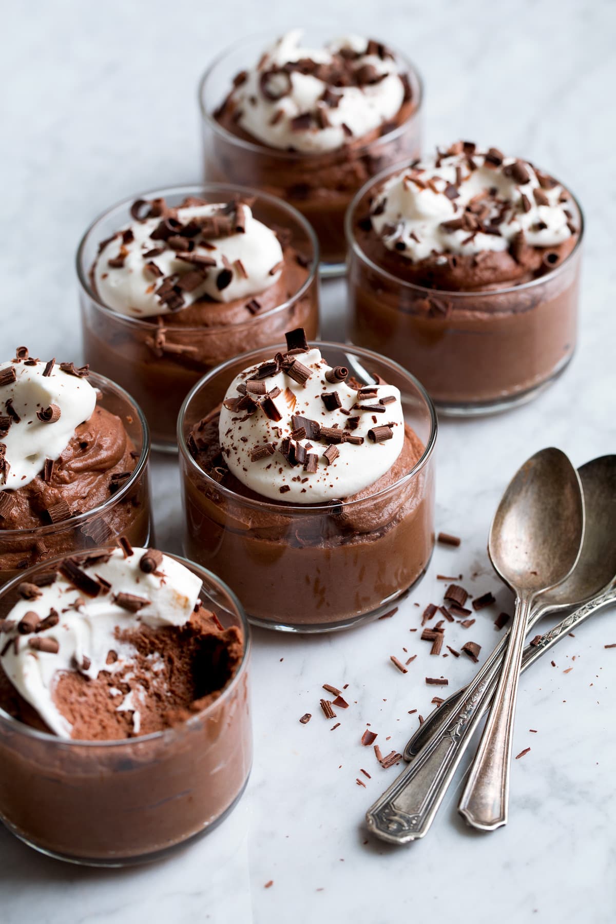 6 servings of chocolate mousse in small glass cups.